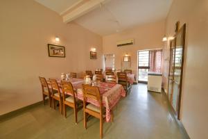 a dining room with a long table and chairs at Hotel Jai Niwas in Jaipur