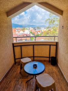 a table and two stools on a balcony with a view at Gurman in Strumica