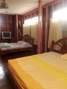 1 dormitorio con 2 camas y TV. en นาหินลาดรีสอร์ท Nahinlad Resort en Ban Khok Sawang (2)