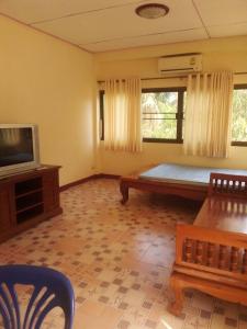 uma sala de estar com uma cama e uma televisão em นาหินลาดรีสอร์ท Nahinlad Resort em Ban Khok Sawang (2)