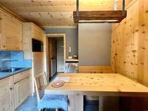 uma cozinha com uma mesa de madeira num quarto em Al Bait Del Legn 1 em Bormio