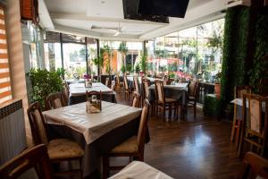 a dining room with tables and chairs and windows at Gurman in Strumica