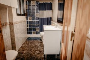 baño con 2 aseos, lavamanos y ventana en Casa Lavanda, en Villena