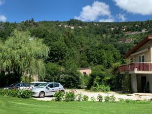 dos autos estacionados en un patio al lado de una casa en Le Clapot- Les Iris, en Saint-Étienne