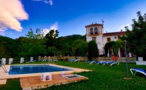 a house with a swimming pool in front of a yard at Cerro de Hijar in Tolox