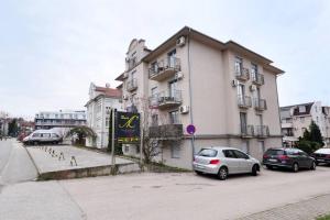 a building with cars parked in front of it at Apartman Dačić in Vrnjačka Banja