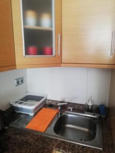 een aanrecht met een wastafel en een magnetron bij Apartamento confortable en la bahia de Alicante in Alicante