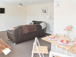 a living room with a leather couch and a table at Swans Nest - Uk43545 in Belford