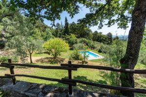 a garden with a swimming pool and a wooden fence at Tuscan Countryside Paradise with Pool in Cavriglia