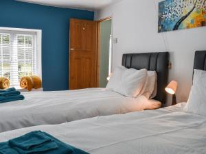 two beds in a bedroom with blue walls at The Old Post House in Walton