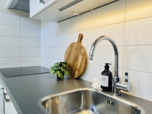 encimera de cocina con fregadero y tabla de cortar de madera en Kranenbergh Boutique Apartments, en Bergen