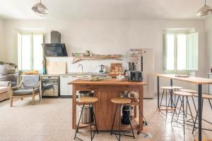 a kitchen with a wooden island and bar stools at Safeheaven Sardinia in Dorgali