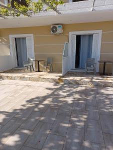 a patio with chairs and a table in front of a building at Ionian View Guest House in Qeparo