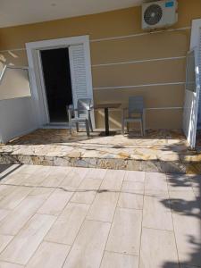 a patio with chairs and a table next to a building at Ionian View Guest House in Qeparo