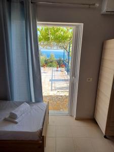 1 dormitorio con puerta que conduce a un patio en Ionian View Guest House en Qeparo