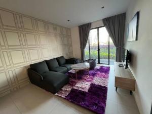 een woonkamer met een zwarte bank en een tafel bij Armadale Residence Galacity 3 bedroom in Kampong Tabuan