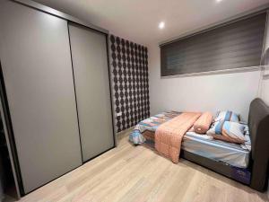 een slaapkamer met een bed en een glazen schuifdeur bij Armadale Residence Galacity 3 bedroom in Kampong Tabuan