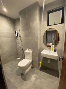 een badkamer met een toilet, een wastafel en een spiegel bij Armadale Residence Galacity 3 bedroom in Kampong Tabuan
