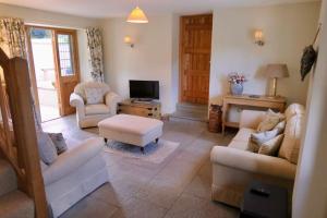 a living room with two couches and a tv at The Tallet - converted three bed stable - no children under 8 in Yeovil
