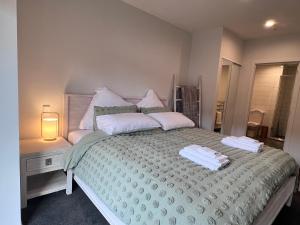 um quarto com uma cama com duas toalhas em 3 bedroom apartment in Newmarket em Auckland