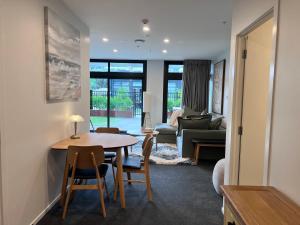 ein Wohnzimmer mit einem Tisch, Stühlen und einem Sofa in der Unterkunft 3 bedroom apartment in Newmarket in Auckland
