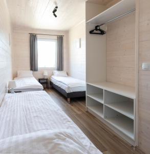 - une chambre avec 2 lits et une fenêtre dans l'établissement Domki Marcela Mielno, à Mielno