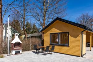 une petite maison jaune avec une table et des chaises dans l'établissement Domki Marcela Mielno, à Mielno