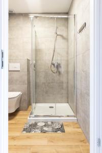 La salle de bains est pourvue d'une douche avec une porte en verre. dans l'établissement Domki Marcela Mielno, à Mielno