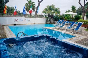 une piscine avec des chaises bleues et une piscine dans l'établissement Villa Cinque Pini, à Ischia