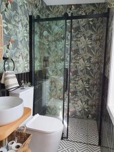 a bathroom with a shower with a toilet and a sink at Tiny house with greenhouse dining in Lower Hutt