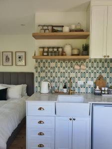 una cocina con fregadero y una cama en una habitación en Tiny house with greenhouse dining en Lower Hutt