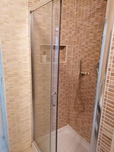 a shower with a glass door in a bathroom at Pennino studios affitti brevi in Bacoli