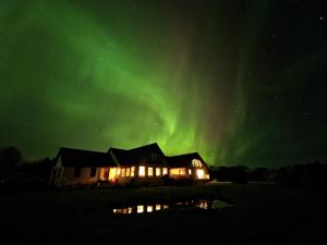a house with the aurora in the sky at Acarsaid B&B in Lybster