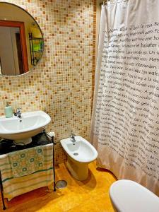 a bathroom with a sink and a toilet and a mirror at People Homes Bajo Guía in Sanlúcar de Barrameda
