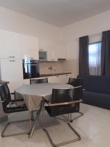 a table and chairs in a room with a kitchen at Villa Milan in Vinkuran +20 photos