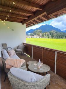 a patio with chairs and tables and a view of a field at Panoramablick in Breitenwang