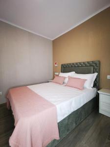 a bedroom with a large bed with pink pillows at Apartamento MS in Campo Maior