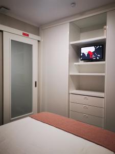 um quarto com uma cama e uma televisão num armário em Apartamento MS em Campo Maior