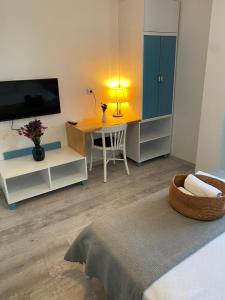 sala de estar con TV y mesa con silla en OtelUrla, en Urla