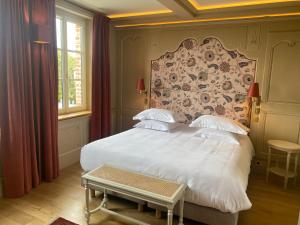 een slaapkamer met een wit bed met een groot hoofdeinde bij La Petite Lucie in Honfleur