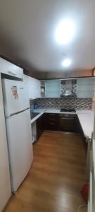 a kitchen with a white refrigerator and wooden floors at مجمع انوفيا2 in Esenyurt