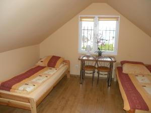 a attic room with two beds and a table at Pokoje Gościnne U Kowala in Polańczyk
