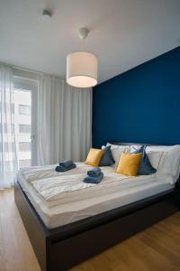 Cama grande en habitación con pared azul en Modern apartment near Stadtpark en Viena