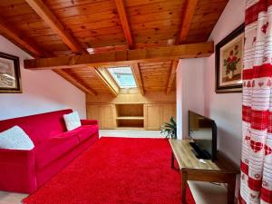 Chalet Ame في بورميو: غرفة معيشة مع أريكة حمراء وسجادة حمراء