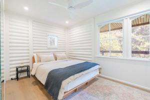 a white bedroom with a bed and a window at Harberts Lodge Yarra Valley in Launching Place