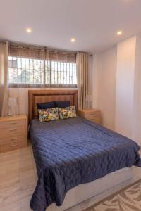 1 dormitorio con cama con sábanas azules y ventana en Beautiful and elegant one bedroom apartment, en Fuengirola