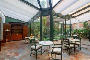 an indoor patio with tables and chairs and windows at Albergo Pietrasanta in Pietrasanta