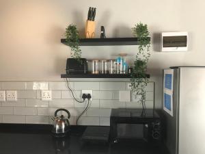una cocina con azulejos blancos y negros en la pared en Blue Lotus Guest House Pta East-No Loadshedding, en Pretoria
