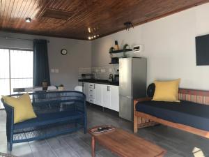 uma sala de estar com dois sofás azuis e uma cozinha em Blue Lotus Guest House Pta East-No Loadshedding em Pretoria