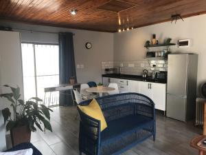 a kitchen with a blue couch in a kitchen with a refrigerator at Blue Lotus Guest House Pta East-Solar power in Pretoria